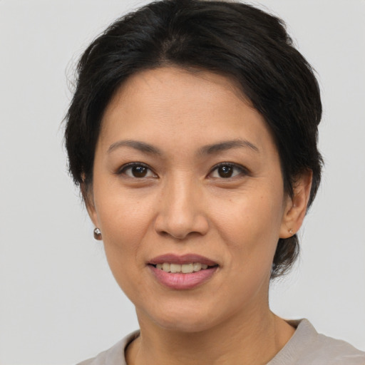 Joyful asian adult female with short  brown hair and brown eyes