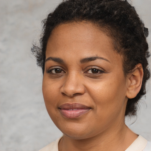 Joyful black young-adult female with short  brown hair and brown eyes