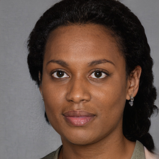 Joyful black young-adult female with short  black hair and brown eyes