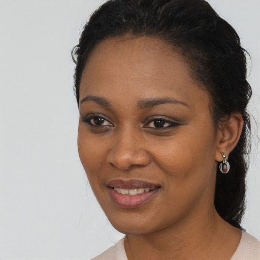 Joyful black young-adult female with long  black hair and brown eyes