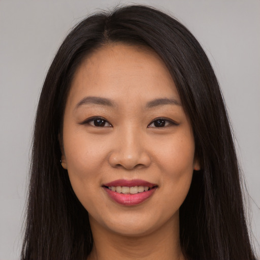 Joyful asian young-adult female with long  brown hair and brown eyes