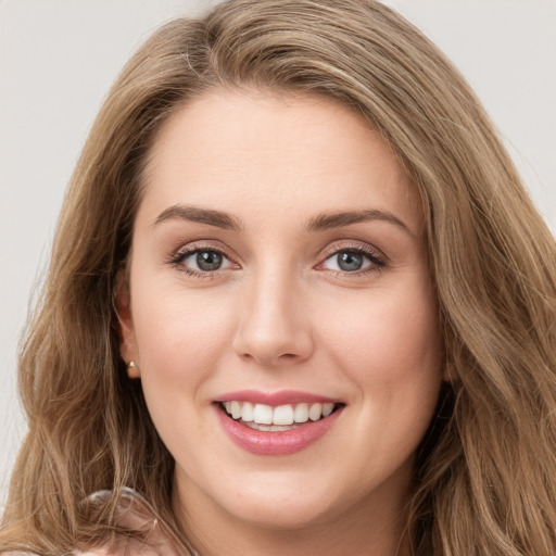 Joyful white young-adult female with long  brown hair and blue eyes