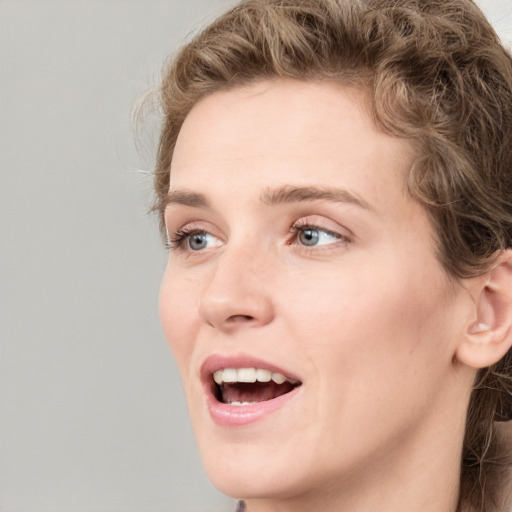 Joyful white young-adult female with medium  brown hair and green eyes