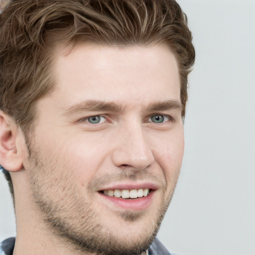 Joyful white young-adult male with short  brown hair and blue eyes