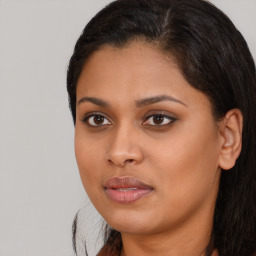 Joyful black young-adult female with long  brown hair and brown eyes