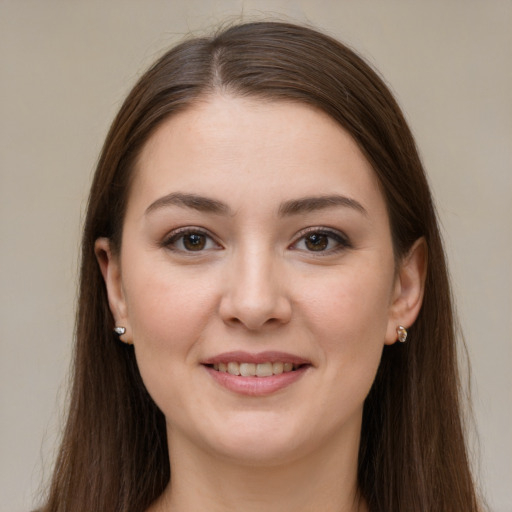 Joyful white young-adult female with long  brown hair and brown eyes