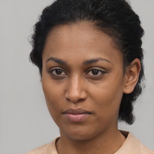 Joyful black young-adult female with short  brown hair and brown eyes