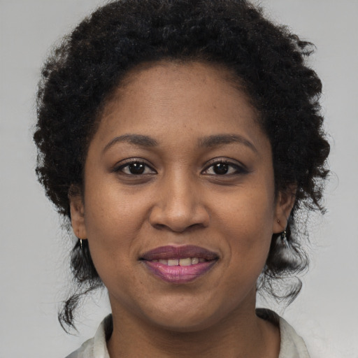 Joyful black adult female with short  brown hair and brown eyes