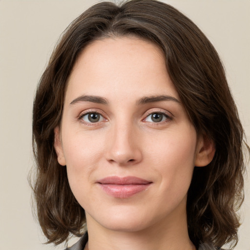 Joyful white young-adult female with medium  brown hair and green eyes