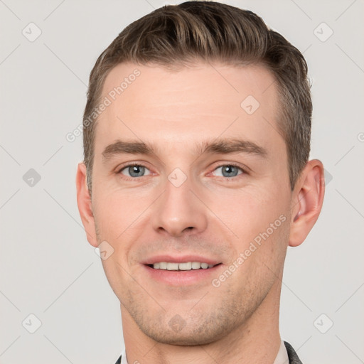 Joyful white young-adult male with short  brown hair and grey eyes