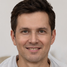 Joyful white adult male with short  brown hair and brown eyes