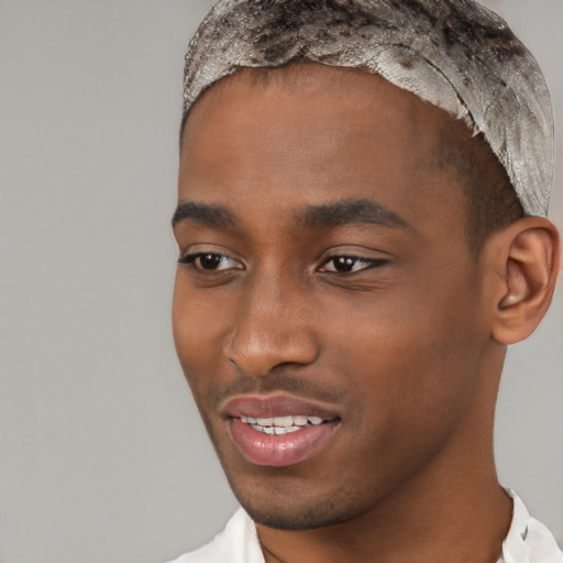 Joyful black young-adult male with short  brown hair and brown eyes