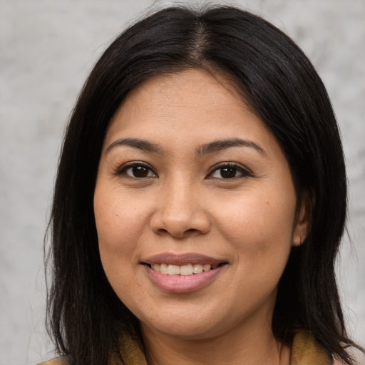 Joyful asian young-adult female with long  brown hair and brown eyes