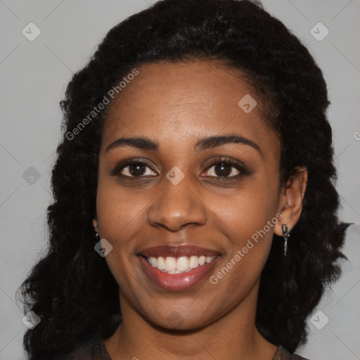 Joyful black young-adult female with long  black hair and brown eyes