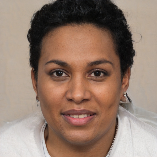 Joyful black young-adult female with short  black hair and brown eyes