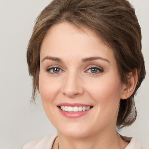 Joyful white young-adult female with medium  brown hair and green eyes