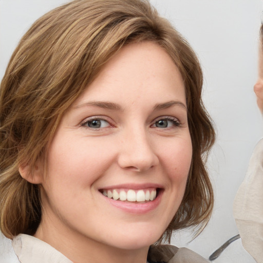 Joyful white young-adult female with medium  brown hair and grey eyes