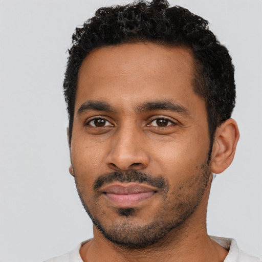 Joyful black young-adult male with short  black hair and brown eyes
