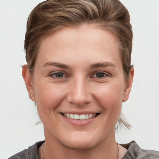 Joyful white young-adult female with short  brown hair and grey eyes