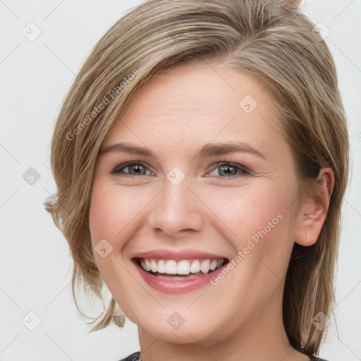 Joyful white young-adult female with medium  brown hair and grey eyes