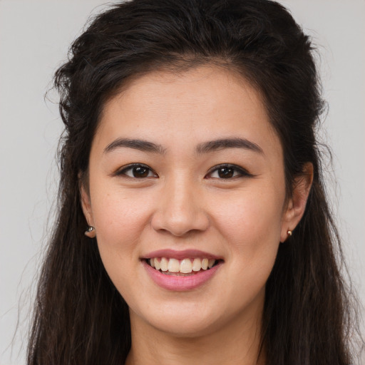 Joyful white young-adult female with long  brown hair and brown eyes