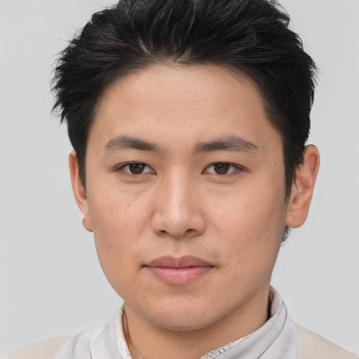 Joyful asian young-adult male with short  brown hair and brown eyes