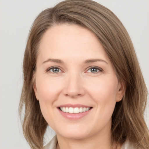 Joyful white young-adult female with medium  brown hair and grey eyes