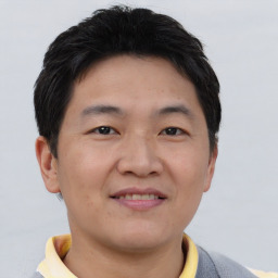 Joyful asian young-adult male with short  brown hair and brown eyes