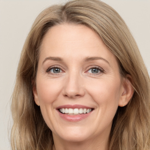 Joyful white adult female with long  brown hair and grey eyes