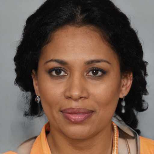 Joyful latino adult female with medium  black hair and brown eyes