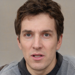 Joyful white adult male with short  brown hair and grey eyes