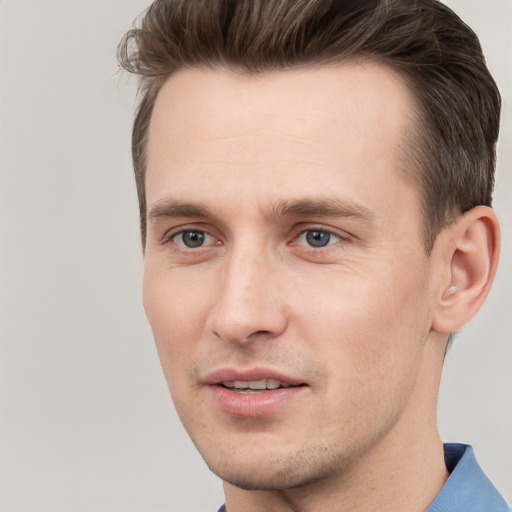 Joyful white young-adult male with short  brown hair and grey eyes