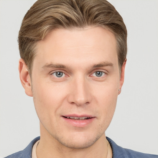 Joyful white young-adult male with short  brown hair and grey eyes