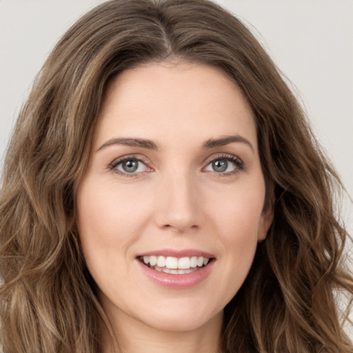 Joyful white young-adult female with long  brown hair and green eyes