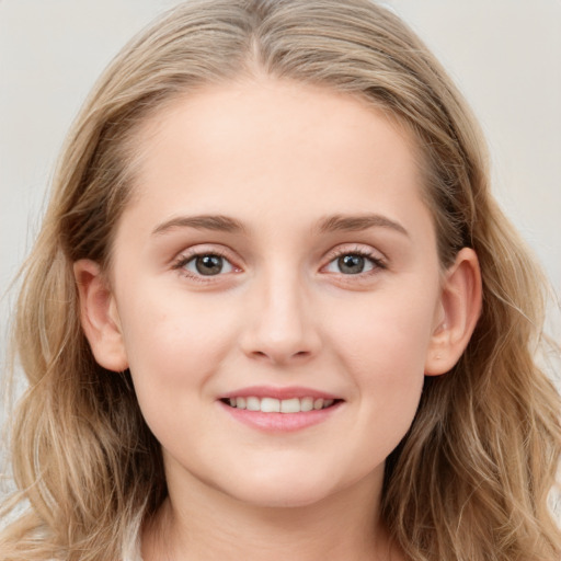 Joyful white young-adult female with long  brown hair and blue eyes