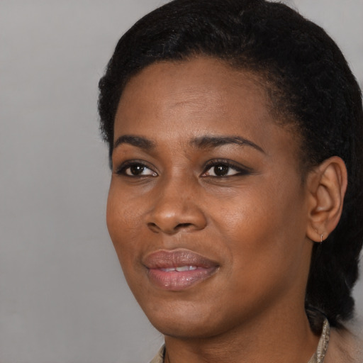 Joyful black young-adult female with short  black hair and brown eyes