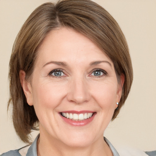 Joyful white adult female with medium  brown hair and grey eyes