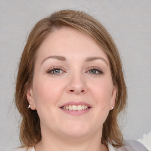 Joyful white young-adult female with medium  brown hair and blue eyes