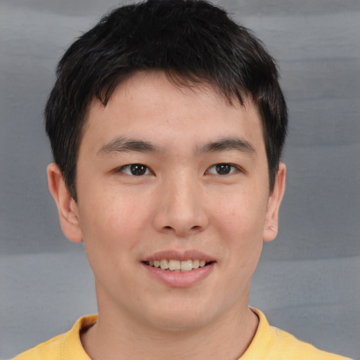 Joyful asian young-adult male with short  brown hair and brown eyes