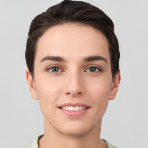 Joyful white young-adult male with short  brown hair and grey eyes