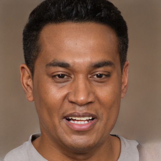 Joyful black adult male with short  brown hair and brown eyes