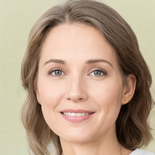 Joyful white young-adult female with medium  brown hair and green eyes