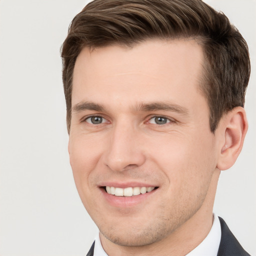 Joyful white young-adult male with short  brown hair and grey eyes