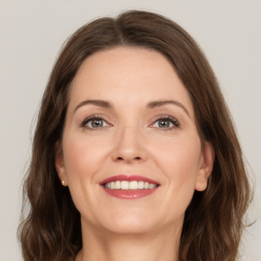 Joyful white young-adult female with medium  brown hair and grey eyes