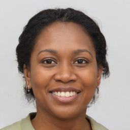 Joyful black adult female with long  brown hair and brown eyes