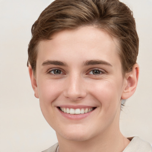 Joyful white young-adult female with short  brown hair and grey eyes