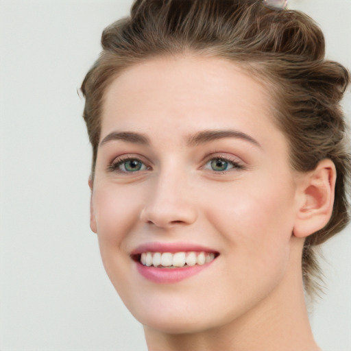 Joyful white young-adult female with short  brown hair and blue eyes