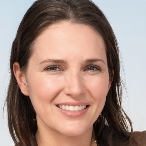 Joyful white young-adult female with long  brown hair and grey eyes