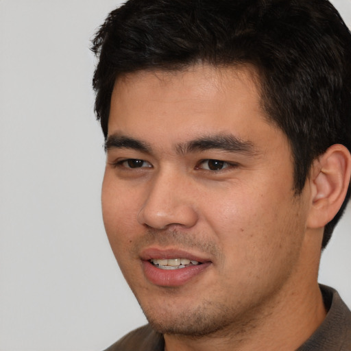 Joyful white young-adult male with short  black hair and brown eyes