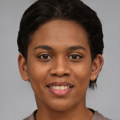 Joyful black young-adult female with short  brown hair and brown eyes